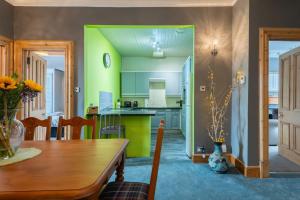 cocina con paredes verdes y mesa de madera en Bridge View Apartments, en Dundee