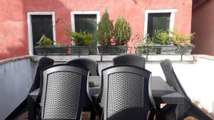 eine Gruppe von Stühlen auf einem Balkon mit Pflanzen in der Unterkunft Ca' del Cafetier in Venedig
