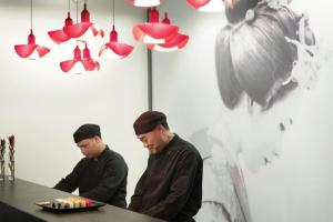EXCELLENCE PUNTA CANA - ALL INCLUSIVE - ADULTS ONLY في بونتا كانا: اثنين من الرجال واقفين على طاولة مع طبق من الطعام