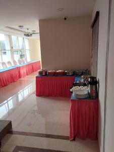um quarto com duas mesas com toalhas de mesa vermelhas em ANNAI RESIDENCY em Vellore