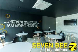 a room with tables and chairs and a sign on the wall at Seven bee boutique hotel in Surin
