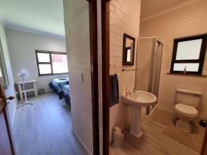 a bathroom with a toilet and a sink at Milkwood Cottage in Bettyʼs Bay +11 photos