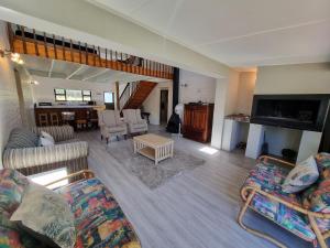 a living room with two couches and a table at Milkwood Cottage in Bettyʼs Bay