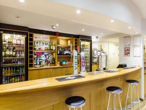un bar en un restaurante con taburetes delante en Travelodge Guildford en Guildford