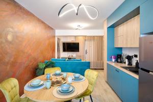 Il comprend une cuisine et un salon avec une table et des chaises. dans l'établissement ZET Apartment in Infinity Beach Resort - parking, à Mamaia