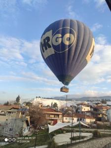 Ein Heißluftballon fliegt über eine Stadt in der Unterkunft Kervansaray Hotel in Pamukkale