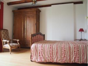 1 dormitorio con 1 cama y armario de madera en St Michel, en Vains