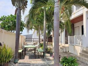 patio z palmami oraz stołem i ławkami w obiekcie Sea beach Koh Larn 2 Hotel w mieście Ko Larn