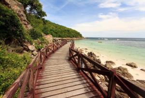 drewniany most nad plażą nad oceanem w obiekcie Sea beach Koh Larn 2 Hotel w mieście Ko Larn