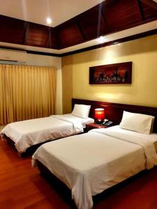 um quarto de hotel com duas camas e um candeeiro em King Hotel em Loei