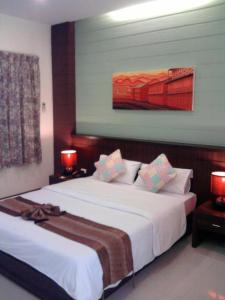 um quarto com duas camas e um quadro na parede em King Hotel em Loei