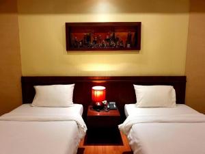 2 letti in una camera d'albergo con una foto appesa alla parete di King Hotel a Loei