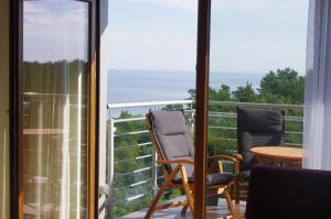 ジブヌベクにあるApartament Przy Plażyの海の景色を望むバルコニー(椅子2脚付)