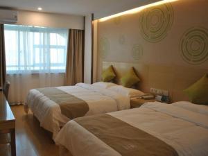 a hotel room with two beds and a window at GreenTree Inn Heze Shan County Huxi South Road Express Hotel in Heze