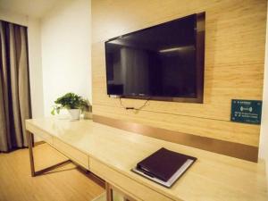 a room with a table with a tv on a wall at GreenTree Inn Heze Shan County Huxi South Road Express Hotel in Heze