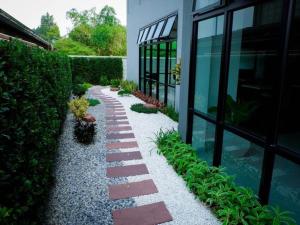 a garden with rocks and plants next to a building at @Sleep in Nakhon Pathom