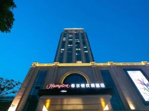 Yuangengshang的住宿－Hampton by Hilton Suzhou XiangCheng，一座高大的建筑,上面有标志
