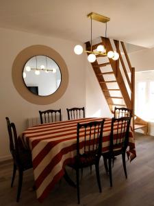 - une salle à manger avec une table, des chaises et un miroir dans l'établissement Appartement cosy chic La Ville au Monnier, à Pleurtuit