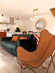 - un salon avec un canapé vert et des chaises dans l'établissement Appartement cosy chic La Ville au Monnier, à Pleurtuit