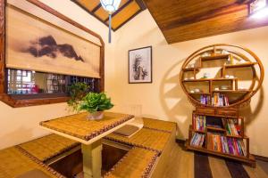 une chambre avec une table et une étagère avec des livres dans l'établissement The Courtyard Suzhou Inn Hemu Branch, à Suzhou