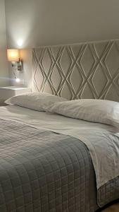 a bedroom with a large bed with a large headboard at Albergo Cerchi in Tortona