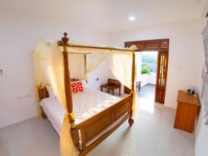 Holiday Home Kalutara في كالوتارا: غرفة نوم مع سرير مظلة في غرفة