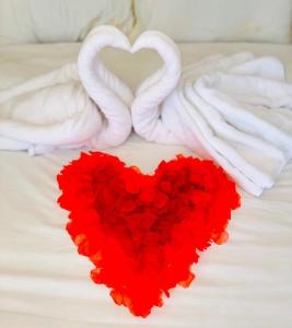 ein rotes Herz auf einem Bett mit zwei Handtüchern in der Unterkunft Ozone by Bankhaokho in Ban Thung Samoe