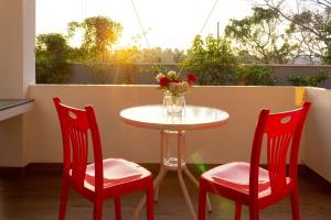 a table and two chairs and a vase with flowers on a balcony at Holiday Home Kalutara in Kalutara