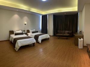 pokój hotelowy z 2 łóżkami i kanapą w obiekcie James Joyce Coffetel Wuhu Wanzhi High-Speed Railway Station w mieście Liangzhongchang