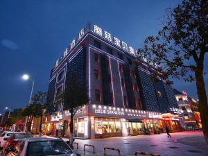 duży budynek na ulicy miejskiej w nocy w obiekcie James Joyce Coffetel Wuhu Wanzhi High-Speed Railway Station w mieście Liangzhongchang