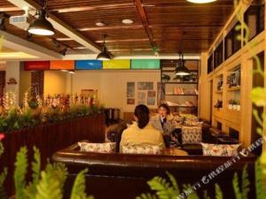 zwei Personen sitzen an einem Tisch in einem Restaurant in der Unterkunft James Joyce Coffetel Lushan Scenic Spot Guling Street Branch in Haihui