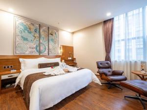 una habitación de hotel con una cama grande y una silla en James Joyce Coffetel Bengbu Yintai City Branch, en Bengbu