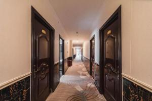 a hallway with dark wooden doors and a long corridor at PAI Hotel Beijing Capital International Airport Linhe Development Zone in Tahe