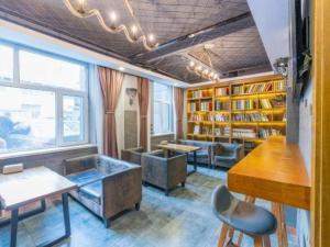 una stanza con biblioteca con tavolo e sedie di James Joyce Coffetel Xining Central Plaza a Xining