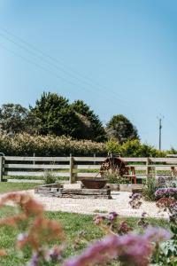 un jardin avec une clôture et des fleurs dans une cour dans l'établissement Kookaburra Cottage - 10 minutes from Mount Gambier CBD, à Yahl Paddock