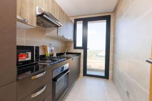 a small kitchen with a stove and a window at Stylish 1BR flat in Hay Riad Central Rabat in Rabat
