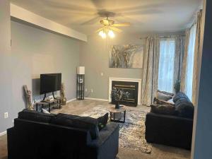 Sala de estar con 2 sofás y TV en Blissful Abode near Washington DC, en Upper Marlboro