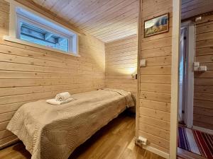 Habitación pequeña con cama y ventana en Lofoten Troll Point, en Bøstad