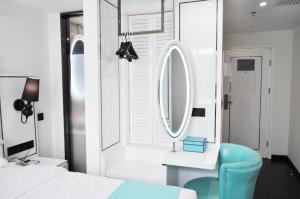 a bedroom with a blue chair and a mirror at Xana Lite Hotel Beijing Daxing International Airport in Yufa