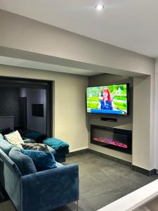 een woonkamer met een bank en een tv bij Big Modern Home in Murrayfield next to the Murrayfield Stadium in Edinburgh