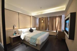 LutingkiaoにあるXana Lite Ganzi Luding YanAn Roadのベッド1台、薄型テレビが備わるホテルルームです。