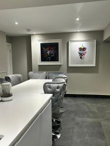 a room with a white counter and some chairs at Big Modern Home in Murrayfield next to the Murrayfield Stadium in Edinburgh