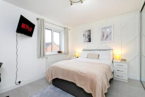 a white bedroom with a bed and a window at 4 Bed Contractor House-Parking-WiFi-Smart Tvs in Each Bedroom-Special Rates Available in Peterborough