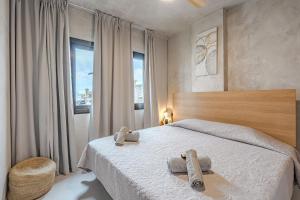Un dormitorio con una cama con dos toallas encima. en Bali Smart Home Hi-End Services Media Streaming, en Adeje