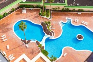 uma vista superior de uma piscina com um resort em Bali Smart Home Hi-End Services Media Streaming em Adeje