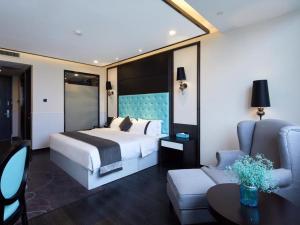a bedroom with a bed and a couch and a chair at Xana Hotelle Yinchuan Dayuecheng Branch in Yinchuan
