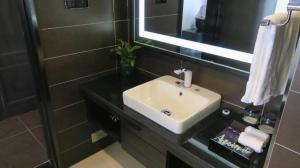 La salle de bains est pourvue d'un lavabo et d'un miroir. dans l'établissement Xana Hotelle Yinchuan Dayuecheng Branch, à Yinchuan