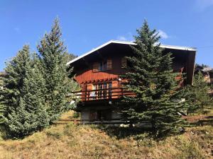 a large wooden house on a hill with two trees at Chalet Chamois - Chalets pour 10 Personnes 214 in Montgenèvre