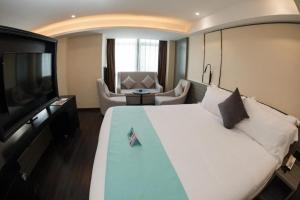 ein Hotelzimmer mit einem großen Bett und einem Flachbild-TV in der Unterkunft Xana Hotelle Nanchang Gaoxin Xincheng Wuyue Plaza in Nanchang