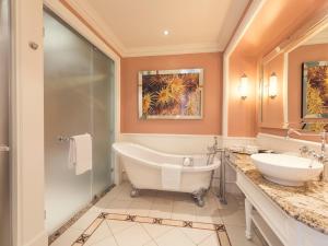 a bath room with a tub, sink and mirror at The Boardwalk Hotel, Convention Centre & Spa in Port Elizabeth